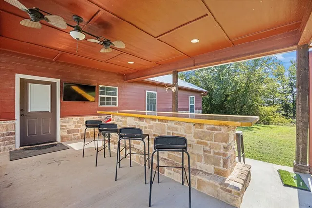 a view of a patio with table and chairs under an umbrella