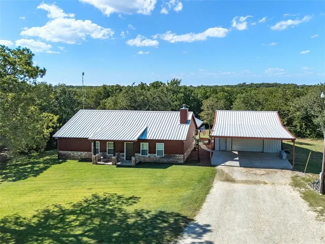 a front view of a house with swimming pool and green yard