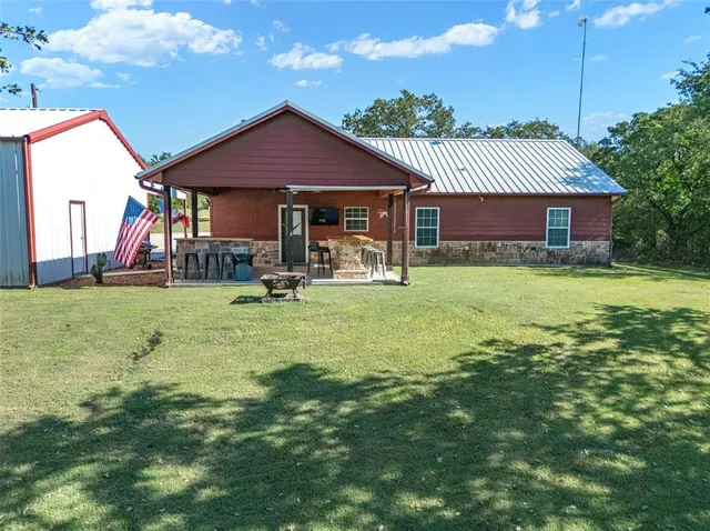 a backyard of a house with table and chairs
