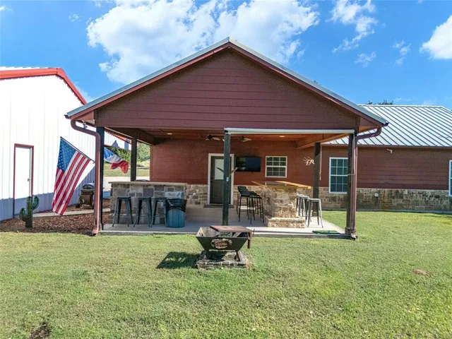 a view of a house with backyard and a patio