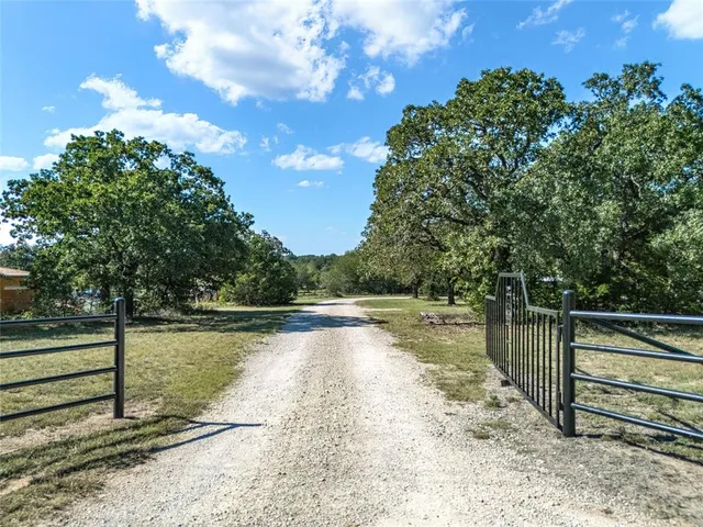 a view of a yard with wooden fence