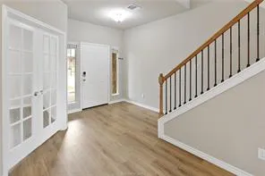 a view of a hallway with wooden floor and staircase