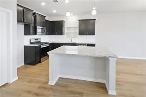 a kitchen with stainless steel appliances granite countertop a sink and a stove