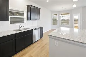 a kitchen with granite countertop kitchen island a sink appliances and a window