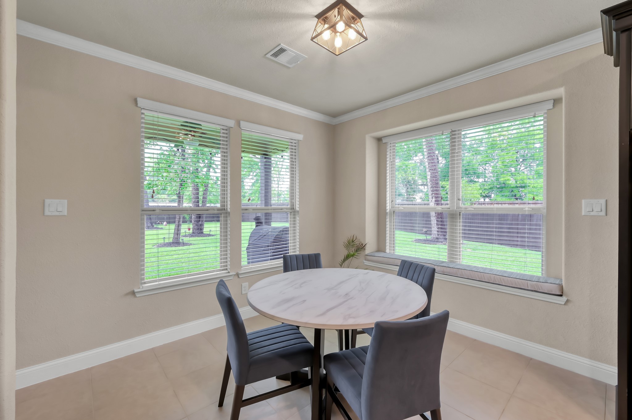 23 Rancher's Trail Tomball, TX 77375 - Photo 16 of 40 Enjoy breakfast bathed in natural light with serene views of the lush, tree-filled yard through expansive windows.