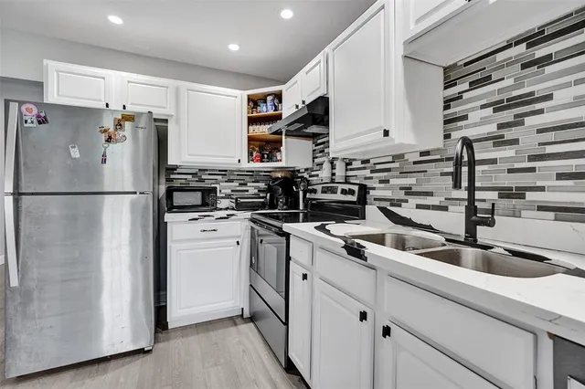 a kitchen with refrigerator and cabinets