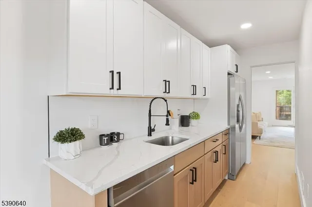 a kitchen with kitchen island a sink and white cabinets