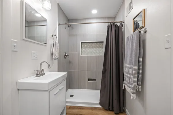 a bathroom with a shower sink and mirror