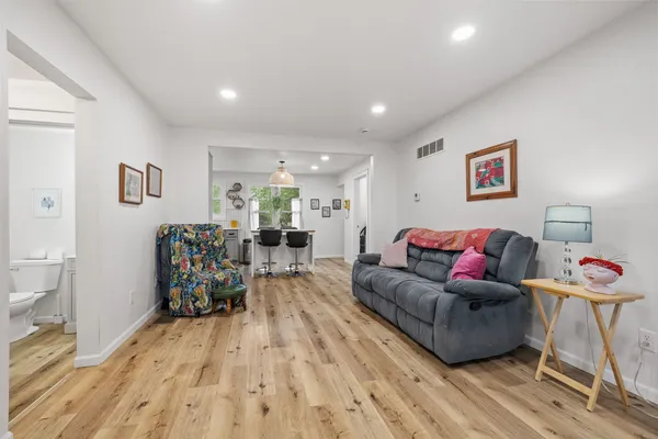 a living room with furniture and a wooden floor