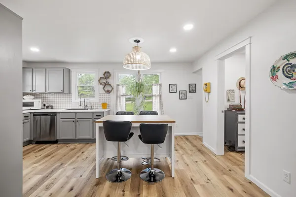 a kitchen with a table chairs refrigerator and microwave
