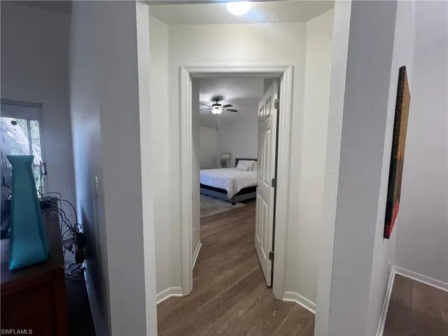 a view of a hallway with livingroom and furniture