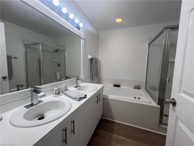 a bathroom with a sink double vanity granite tub and shower