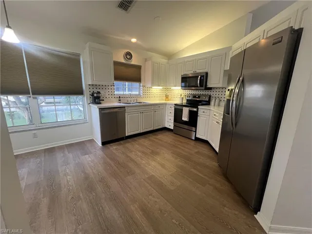 a kitchen with stainless steel appliances a refrigerator sink and microwave