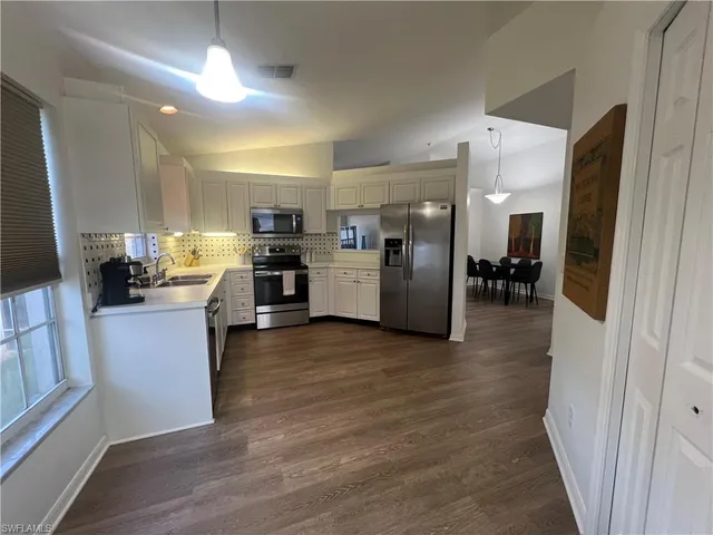 a kitchen with a refrigerator and a stove top oven