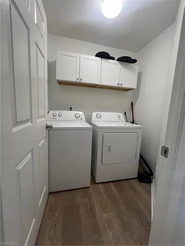a utility room with cabinets washer and dryer