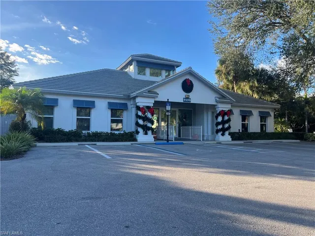 a front view of a house with yard and parking