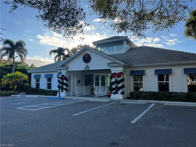 a front view of a house with a tree
