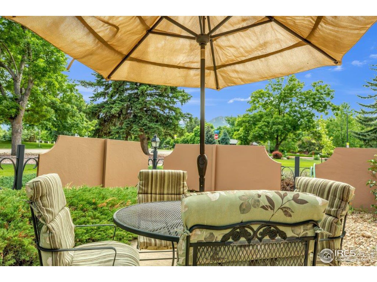 500 Mohawk Drive, Unit 103 Boulder, CO 80303 - Photo 25 of 28 a backyard of a house with table and chairs under an umbrella