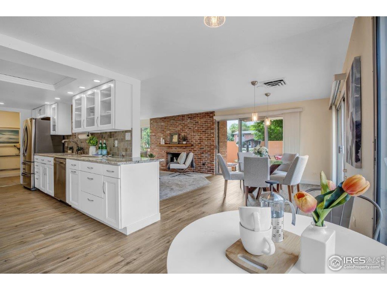 500 Mohawk Drive, Unit 103 Boulder, CO 80303 - Photo 5 of 28 a kitchen with stainless steel appliances granite countertop a refrigerator a stove a sink dishwasher and white cabinets with wooden floor