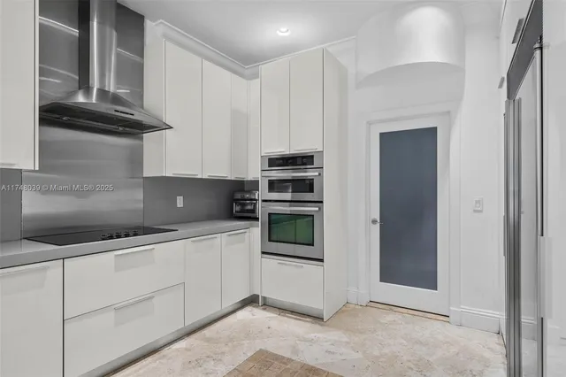 a kitchen with stainless steel appliances granite countertop a refrigerator and a stove top oven