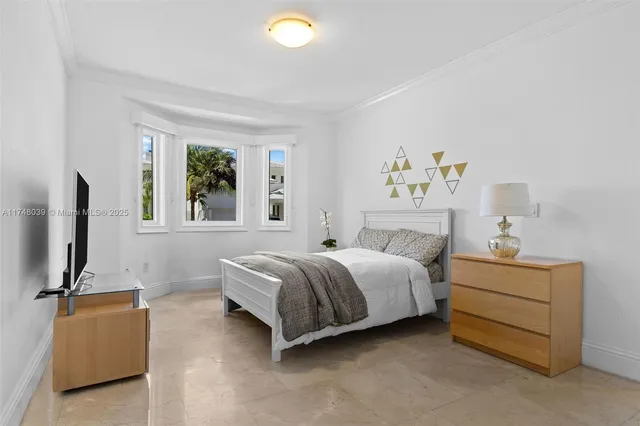 a spacious bedroom with a bed and a flat screen tv