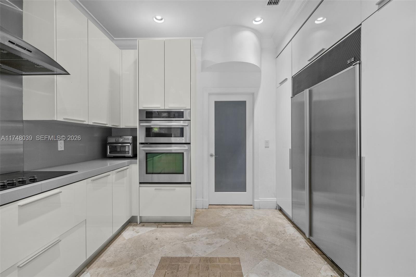 6 Coconut Lane Key Biscayne, FL 33149 - Photo 9 of 49 a kitchen with stainless steel appliances kitchen island granite countertop a refrigerator and a stove top oven