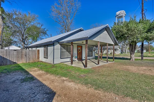 a view of a house with backyard and sitting area