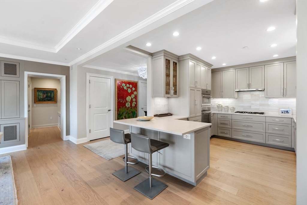 100 Belvidere Street, Unit 7A Boston, MA 02199 - Photo 14 of 40 a kitchen with stainless steel appliances kitchen island granite countertop a table chairs sink and cabinets