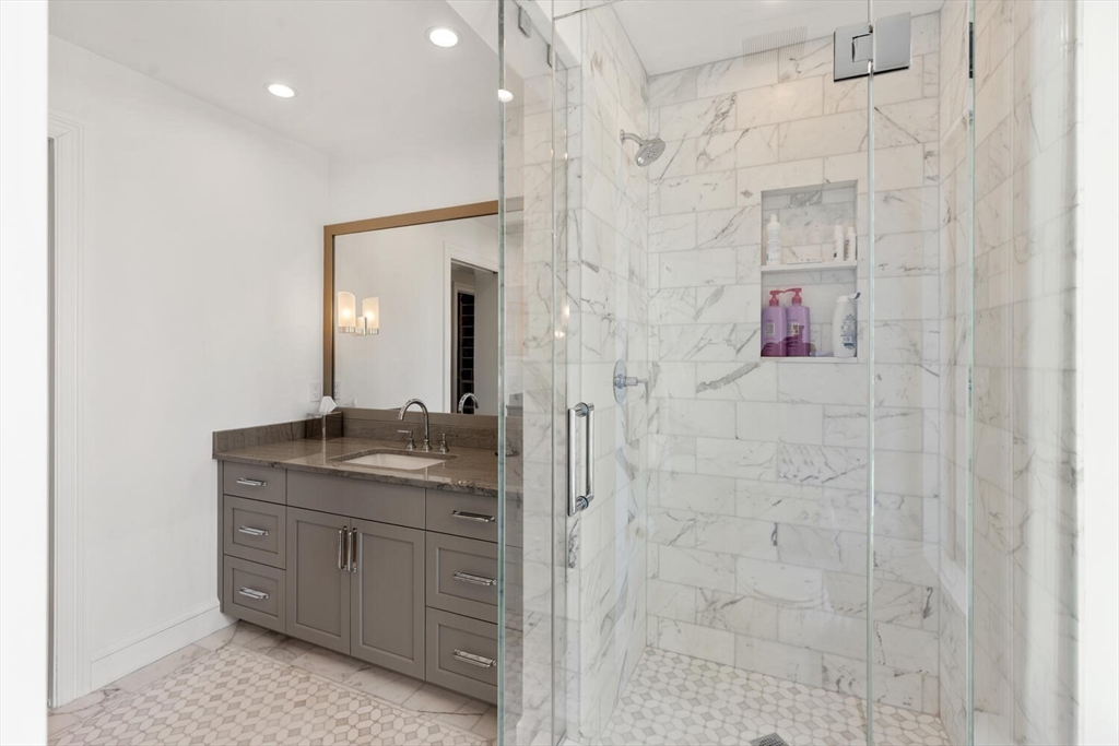 100 Belvidere Street, Unit 7A Boston, MA 02199 - Photo 24 of 40 a bathroom with a granite countertop sink a mirror and shower
