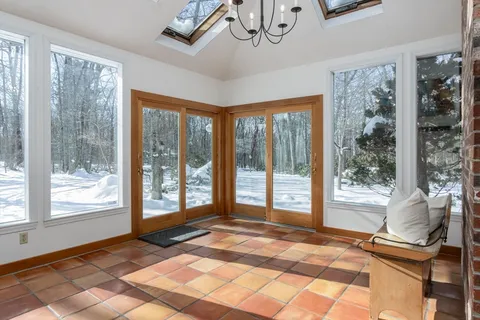a living room with a large window cabinets and dining table chair