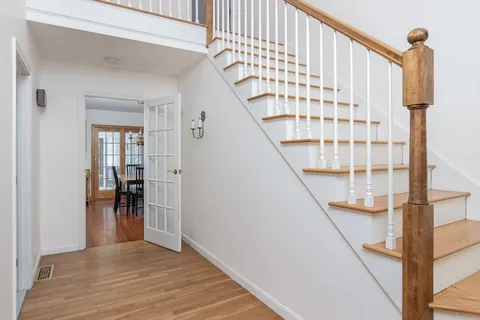 a view of entryway with wooden floor and livingroom view