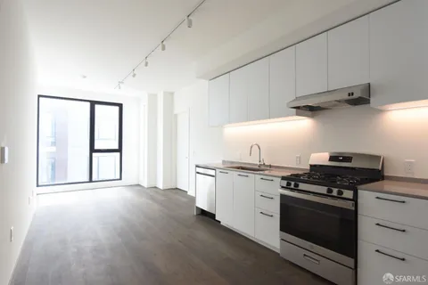 a kitchen with stainless steel appliances a stove and white cabinets