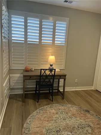 a view of a hallway with wooden floor and a potted plant