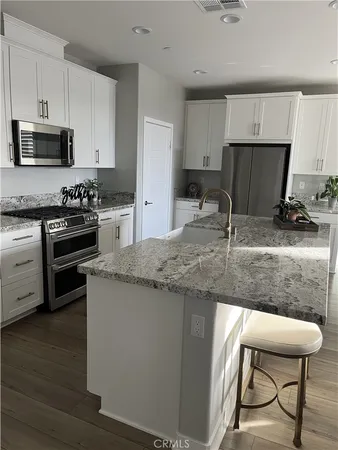 a kitchen with stainless steel appliances granite countertop a stove a sink and a microwave