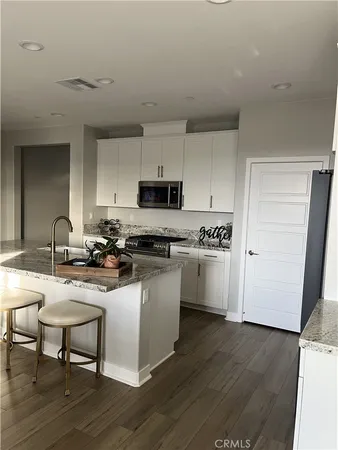 a kitchen with sink a microwave and cabinets