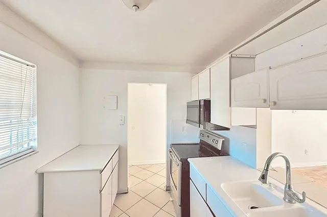 a kitchen with a sink cabinets and appliances