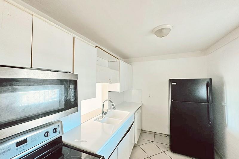2800 Northwest 56th Avenue, Unit G407 Lauderhill, FL 33313 - Photo 3 of 15 a kitchen with a sink a refrigerator and cabinets