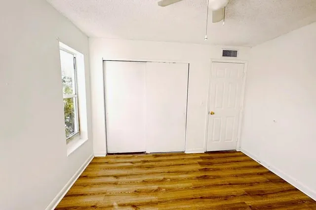 a view of a room with wooden floor and white walls