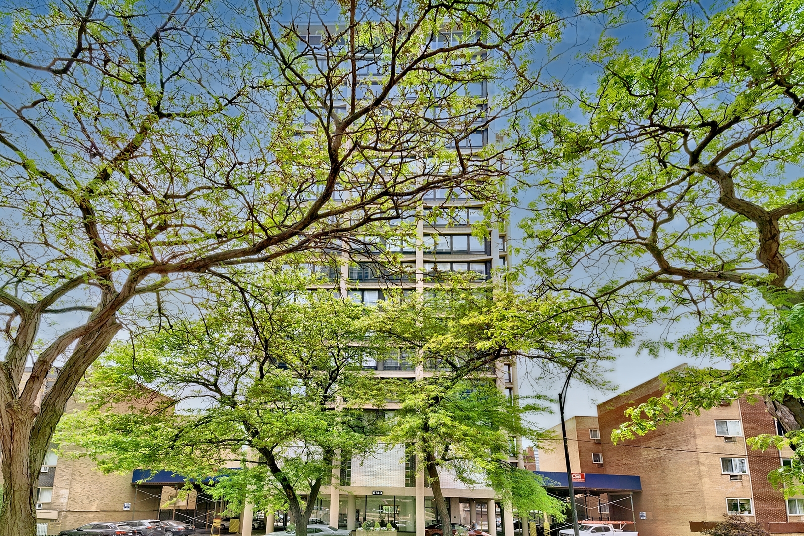 a yellow building with trees in front of it