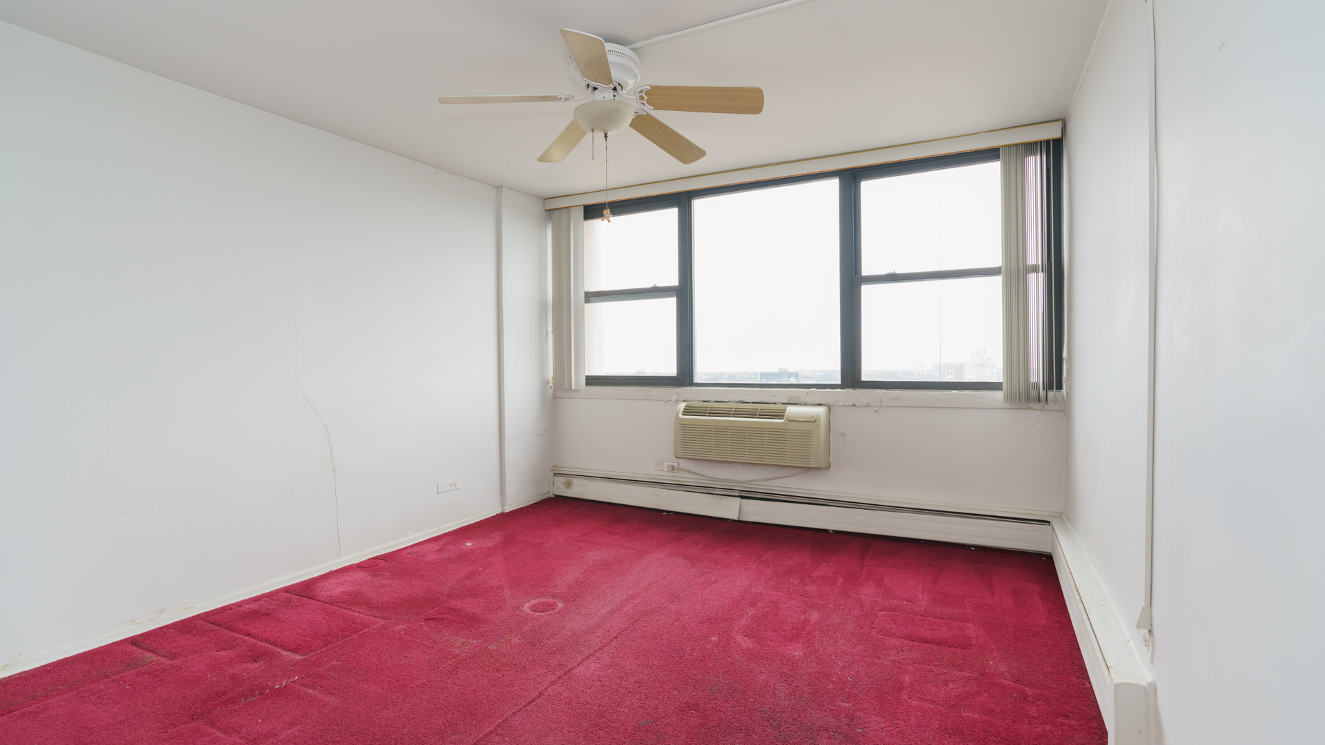 5740 North Sheridan Road, Unit 10D Chicago, IL 60660 - Photo 16 of 22 an empty room with chandelier fan and windows