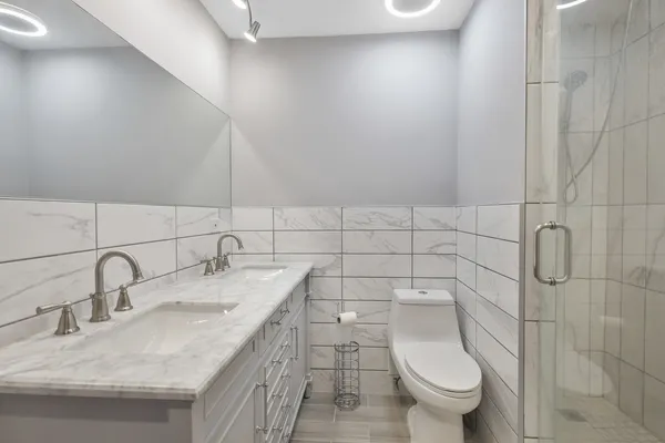 a bathroom with a granite countertop sink a toilet and mirror