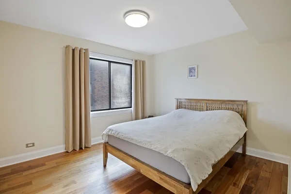 a bed sitting in a bedroom next to a window