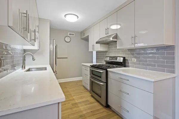 a kitchen with stainless steel appliances granite countertop a sink stove and refrigerator