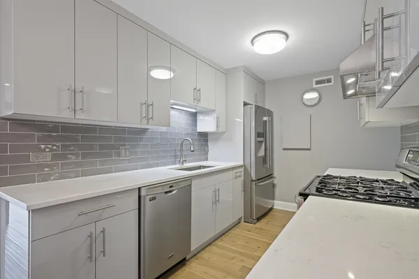 a kitchen with stainless steel appliances a sink stove and cabinets
