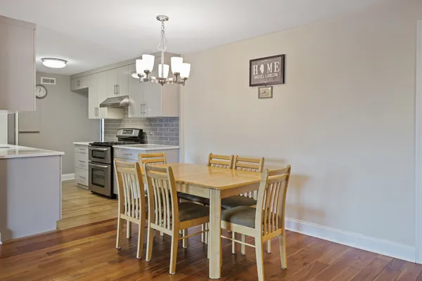 a view of a dining room with furniture wooden floor and a chandelier