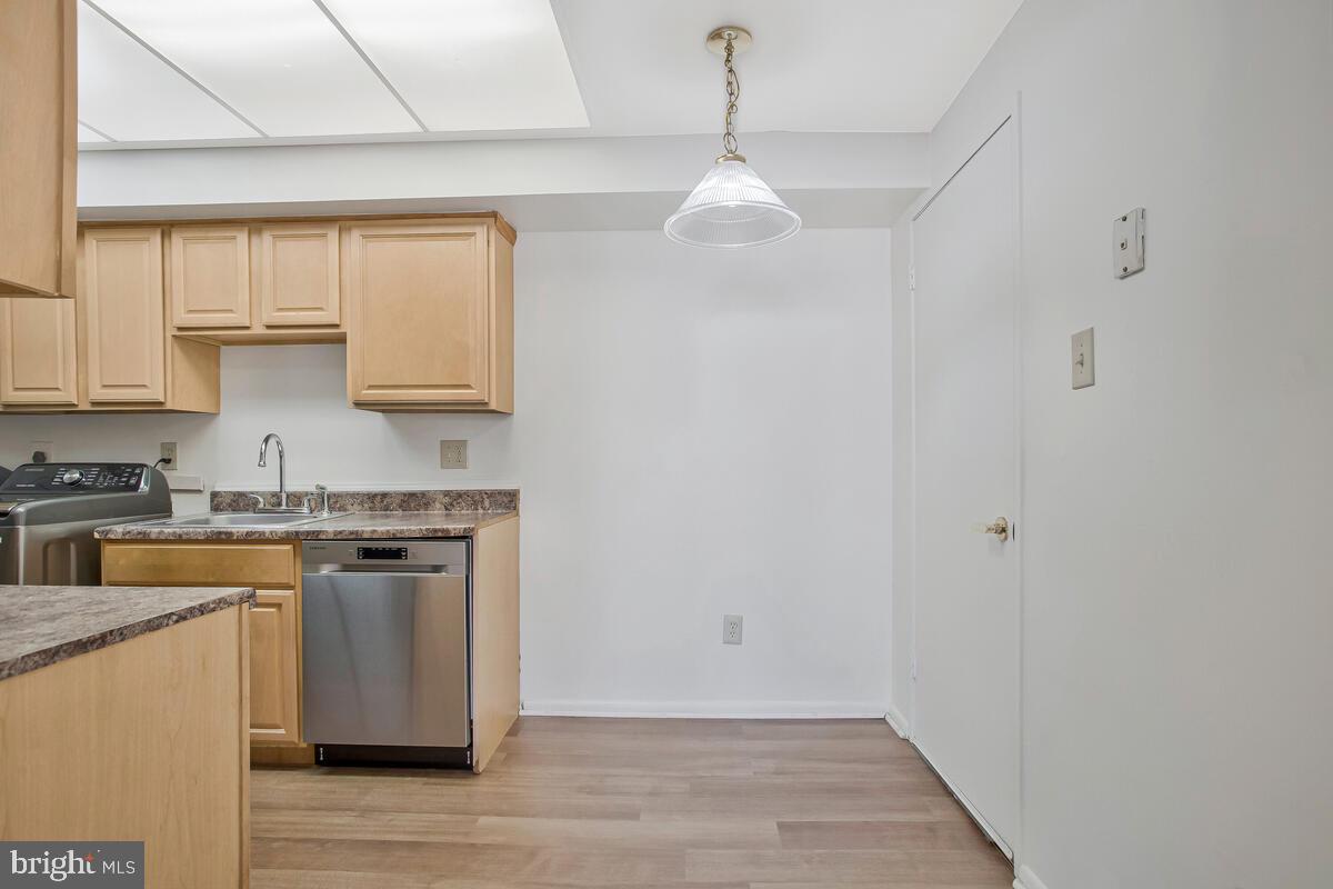 10216 Prince Place, Unit 9204 Upper Marlboro, MD 20774 - Photo 11 of 19 a kitchen with stainless steel appliances granite countertop a sink a stove a refrigerator and island with wooden floor