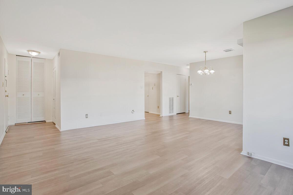 10216 Prince Place, Unit 9204 Upper Marlboro, MD 20774 - Photo 19 of 19 a view of an empty room with wooden floor and a window