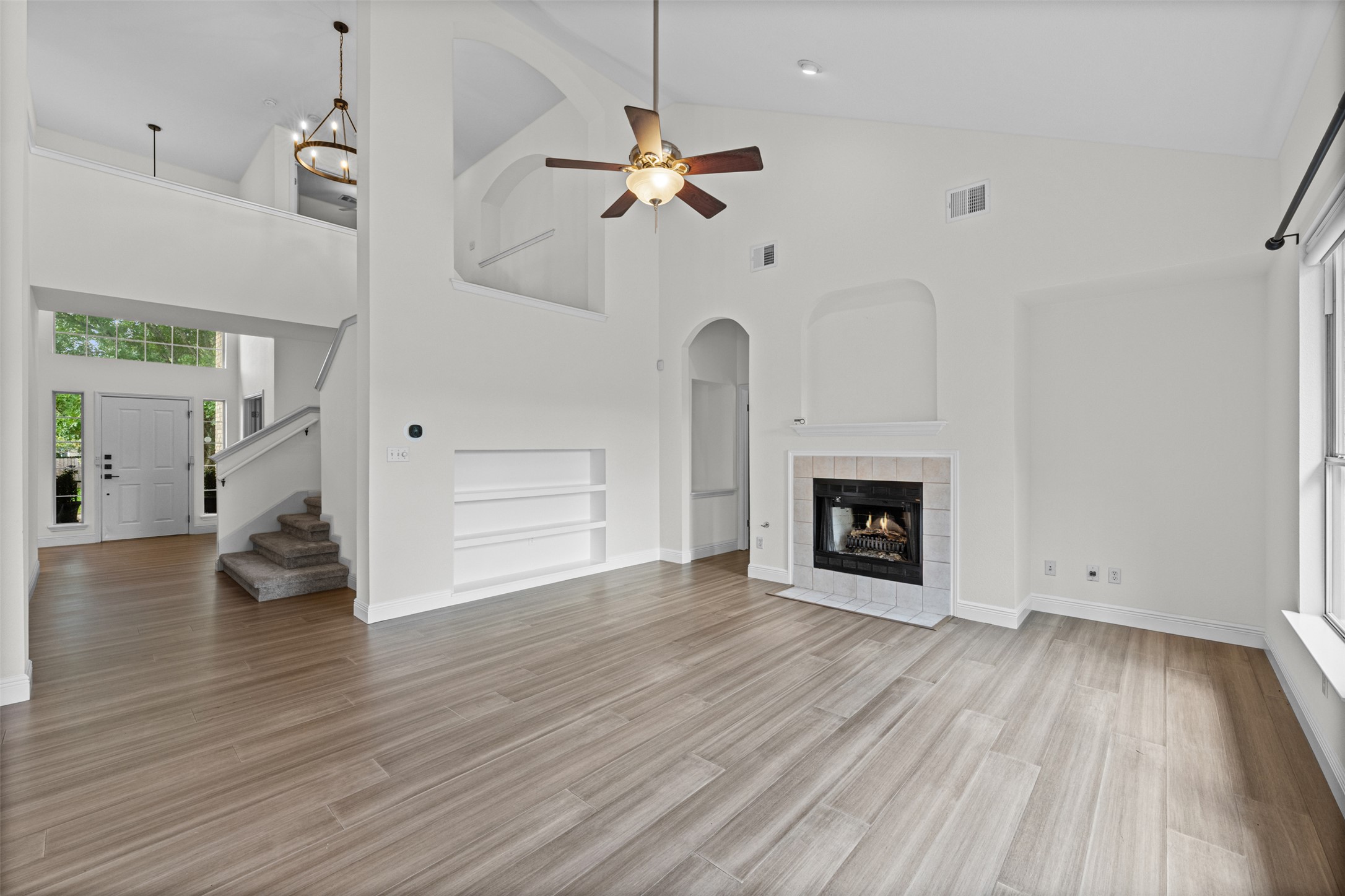 8820 Colberg Drive Austin, TX 78749 - Photo 8 of 35 An inviting living room showcasing high ceilings, a cozy fireplace, and rich flooring.