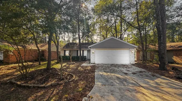 a front view of a house with a yard and large trees