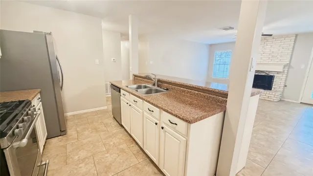 a kitchen with granite countertop a sink stove and refrigerator